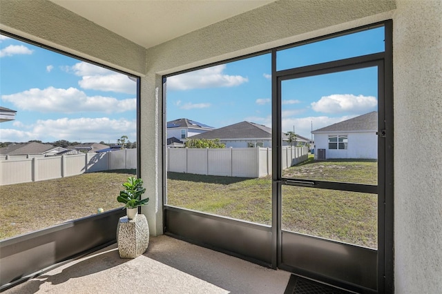 sunroom / solarium featuring plenty of natural light and a residential view