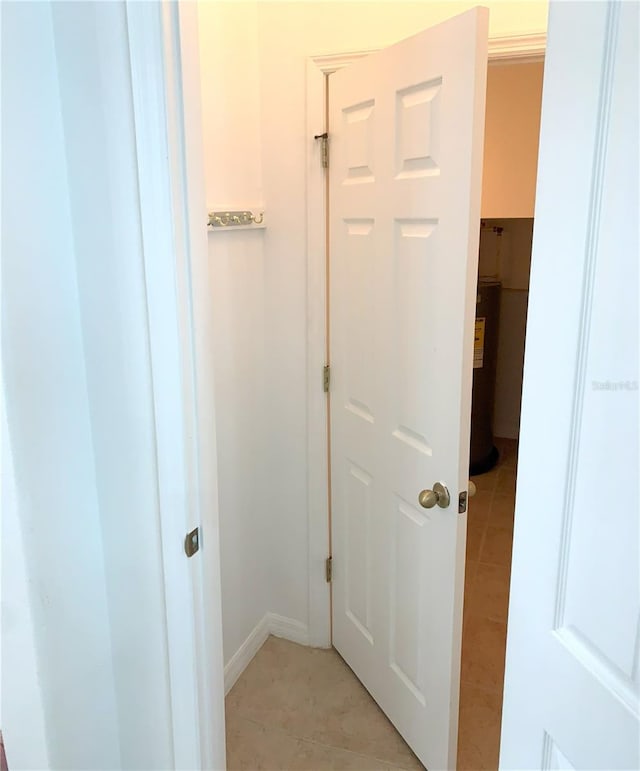 hallway featuring water heater and light tile patterned floors