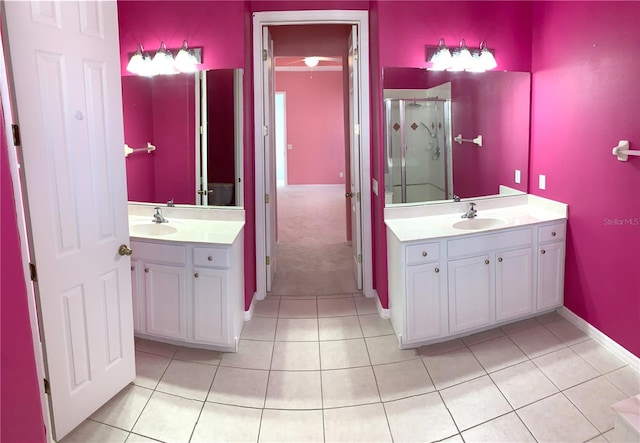 bathroom with a shower with shower door, vanity, and tile patterned flooring