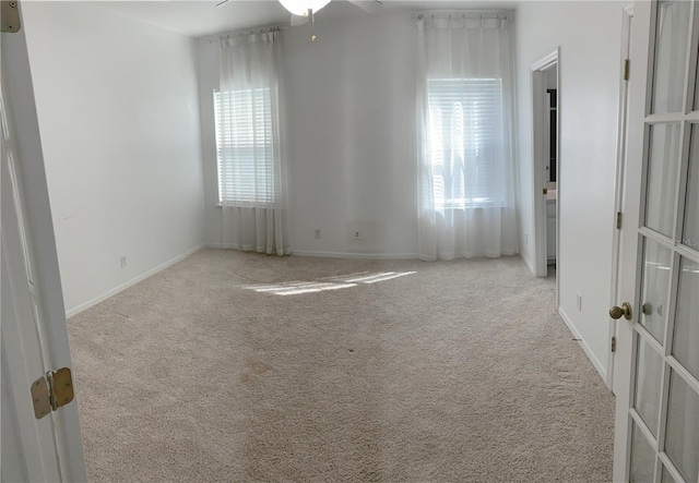 carpeted spare room with ceiling fan