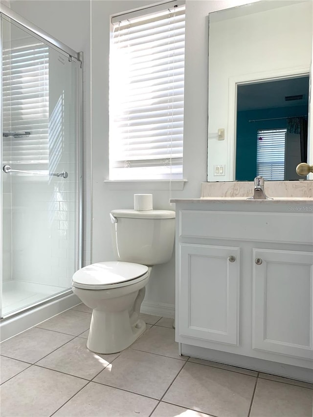 bathroom featuring a shower with shower door, plenty of natural light, and tile patterned flooring