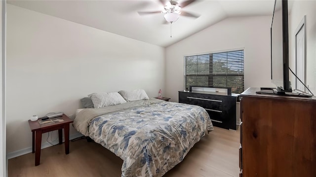 bedroom with a ceiling fan, lofted ceiling, and light wood-type flooring