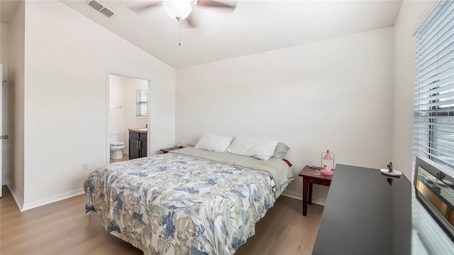 bedroom with lofted ceiling, multiple windows, wood finished floors, and visible vents