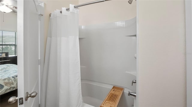 bathroom with ceiling fan and shower / bath combination with curtain