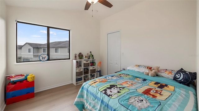 bedroom with ceiling fan, wood finished floors, and baseboards