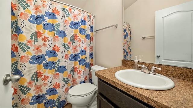 bathroom with curtained shower, vanity, and toilet