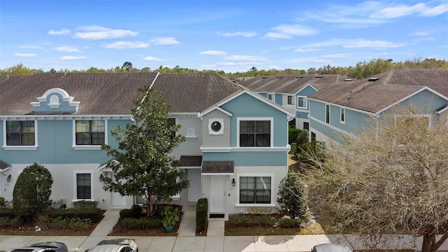 townhome / multi-family property featuring a residential view and stucco siding