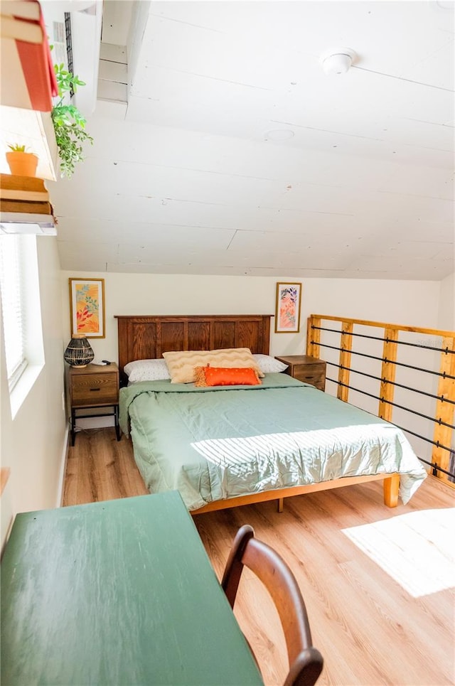 bedroom featuring hardwood / wood-style floors and vaulted ceiling