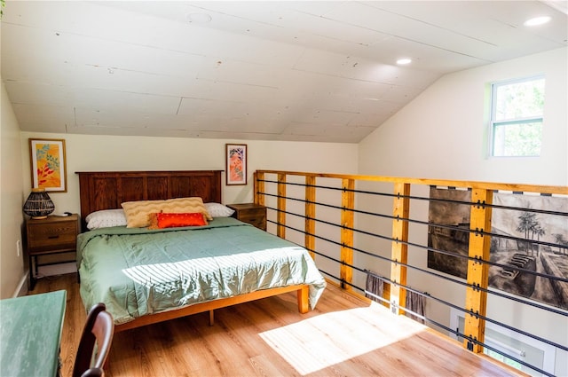 bedroom with wood-type flooring and vaulted ceiling