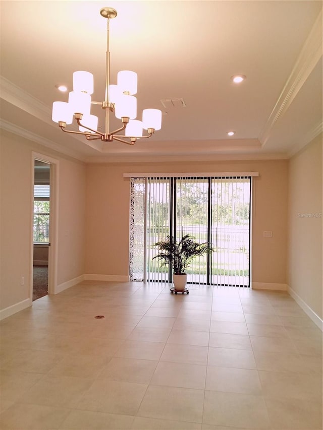 unfurnished room with a raised ceiling, ornamental molding, a wealth of natural light, and an inviting chandelier