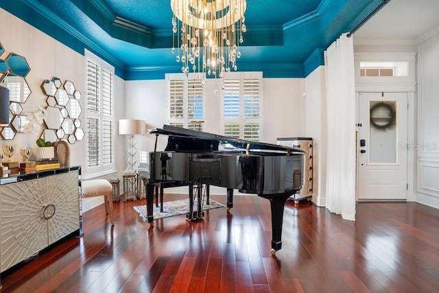 miscellaneous room with a raised ceiling, crown molding, dark hardwood / wood-style floors, and an inviting chandelier