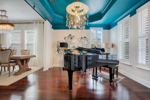 misc room featuring ornamental molding, a textured ceiling, a raised ceiling, wood-type flooring, and an inviting chandelier