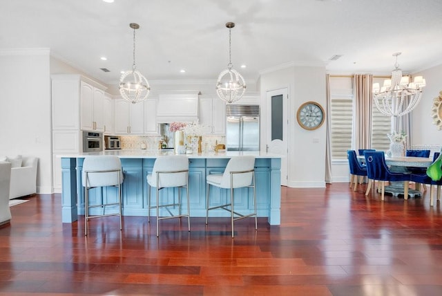 kitchen with white cabinets, decorative light fixtures, appliances with stainless steel finishes, and tasteful backsplash