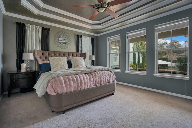 bedroom with carpet, a tray ceiling, ceiling fan, and crown molding