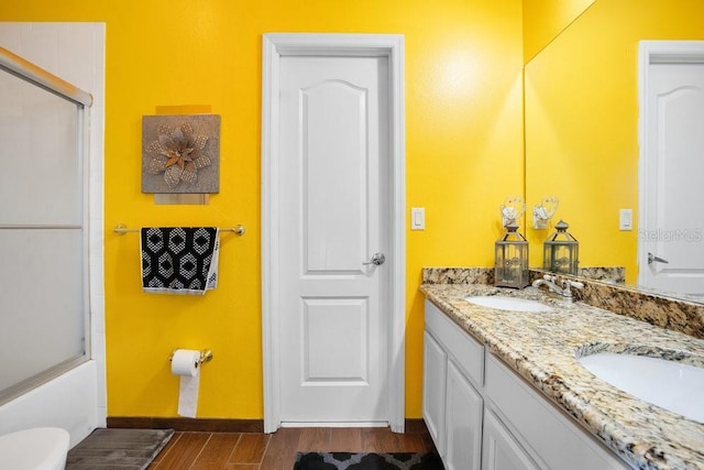 bathroom featuring vanity and bath / shower combo with glass door