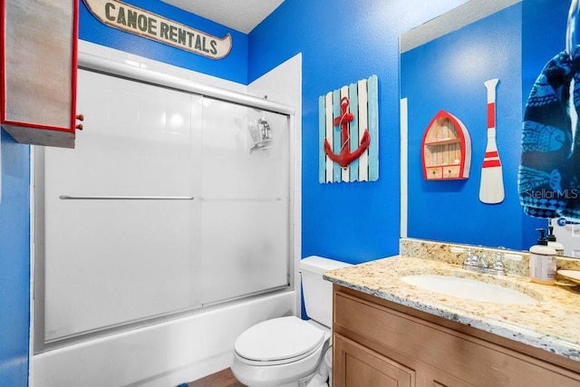 full bathroom featuring combined bath / shower with glass door, vanity, and toilet