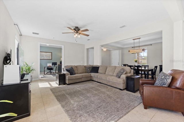 living room with ceiling fan, light tile patterned floors, and ornamental molding