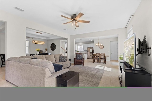 living room featuring light tile patterned floors and ceiling fan with notable chandelier