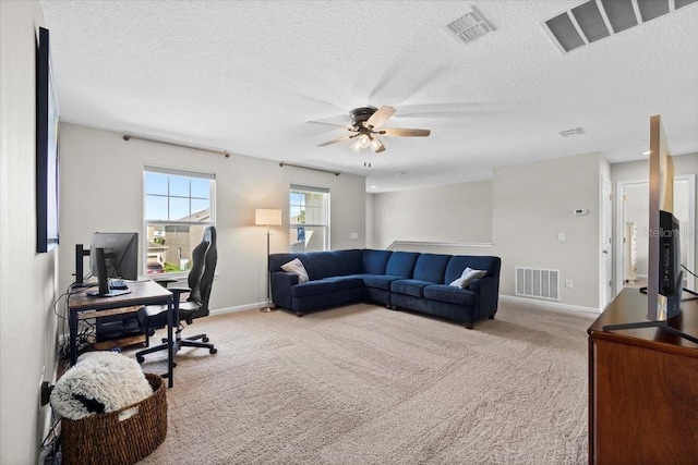 carpeted living room with a textured ceiling and ceiling fan