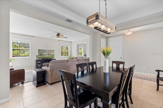 tiled dining space with ceiling fan, a healthy amount of sunlight, and ornamental molding