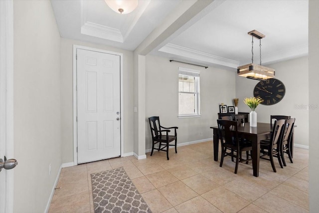 dining area with a raised ceiling, crown molding, and light tile patterned floors