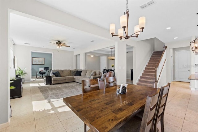 tiled dining space featuring ceiling fan with notable chandelier