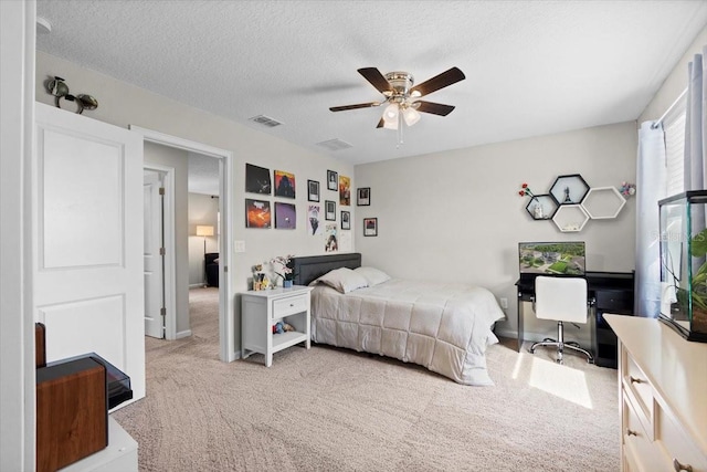 carpeted bedroom featuring ceiling fan and a textured ceiling