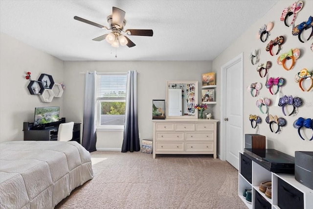 bedroom with a textured ceiling, ceiling fan, and light carpet