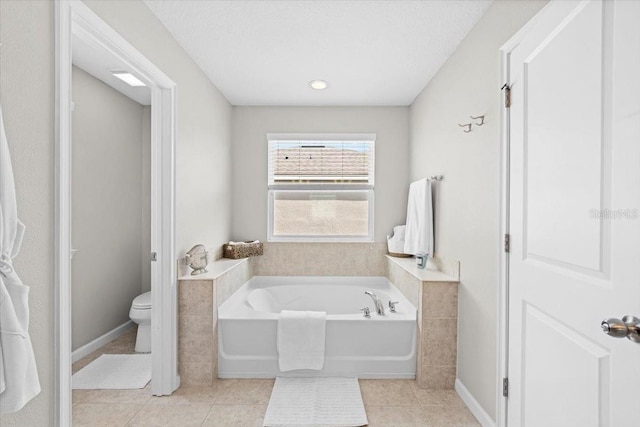 bathroom featuring a tub to relax in, tile patterned flooring, a textured ceiling, and toilet