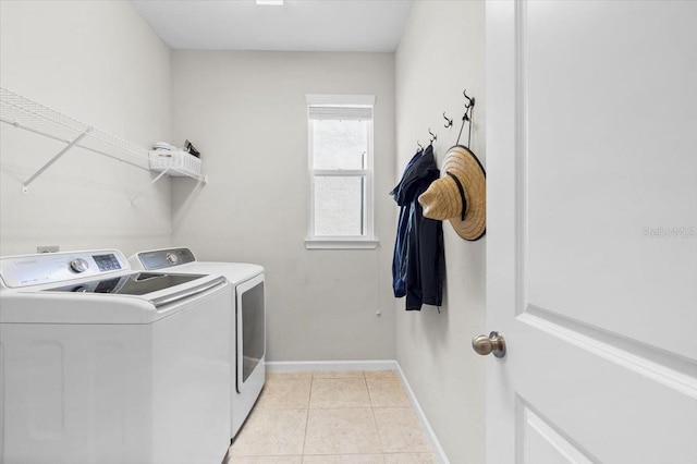 laundry area featuring washing machine and dryer and light tile patterned floors