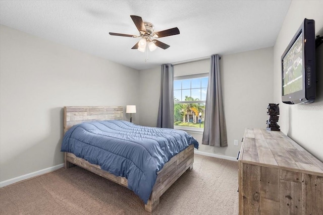 bedroom featuring carpet flooring, ceiling fan, and a textured ceiling