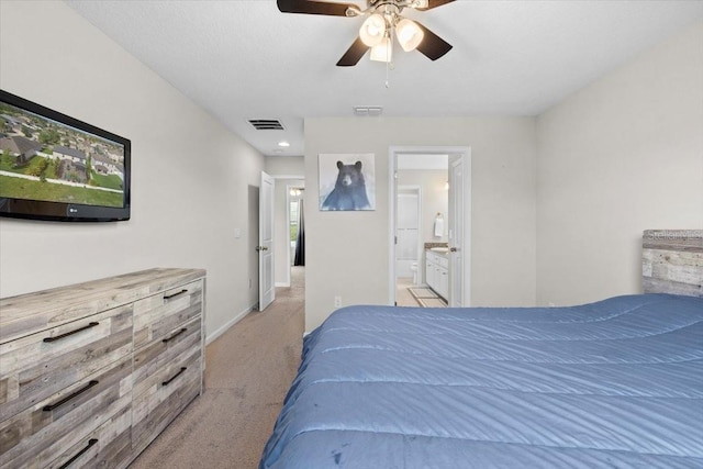 bedroom with ensuite bathroom, ceiling fan, and light colored carpet