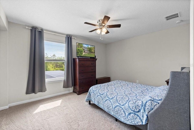 carpeted bedroom with a textured ceiling and ceiling fan