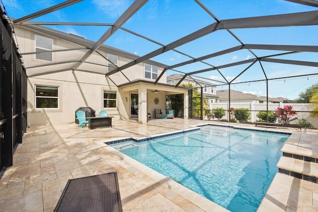 view of pool with a lanai, ceiling fan, and a patio