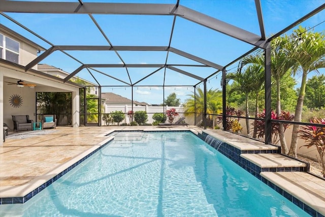 view of swimming pool with a lanai, pool water feature, ceiling fan, and a patio