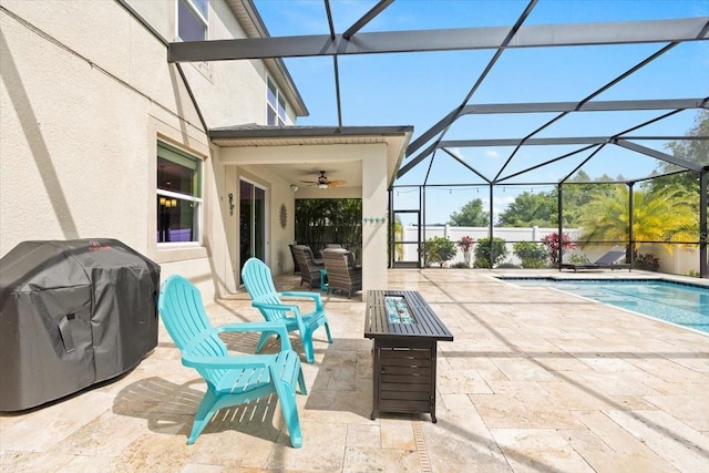 view of patio with glass enclosure, ceiling fan, and a grill