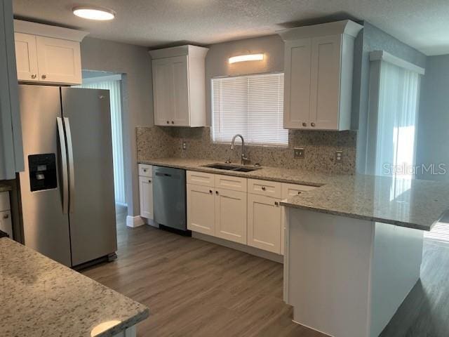 kitchen featuring white cabinets, appliances with stainless steel finishes, plenty of natural light, and sink