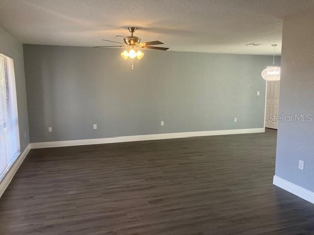 spare room featuring ceiling fan, dark hardwood / wood-style flooring, and a textured ceiling