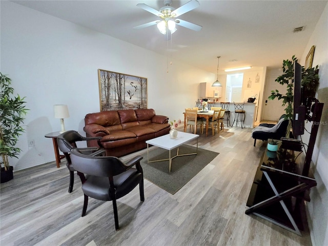 living room featuring ceiling fan and light hardwood / wood-style floors