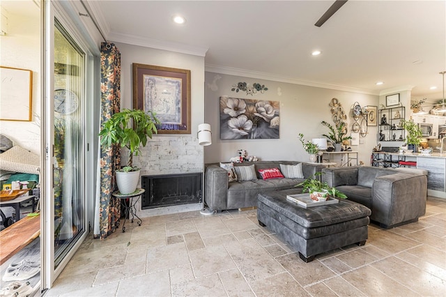 living room featuring a stone fireplace and crown molding