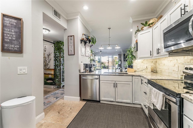 kitchen featuring white cabinets, hanging light fixtures, decorative backsplash, light stone counters, and stainless steel appliances