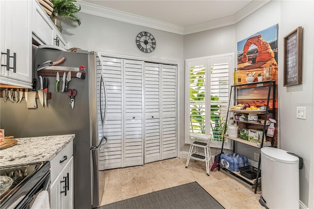 kitchen with light stone countertops, stainless steel fridge, crown molding, white cabinetry, and black electric range oven