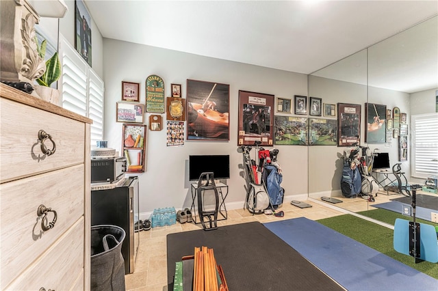 workout area with a wealth of natural light and light tile patterned flooring