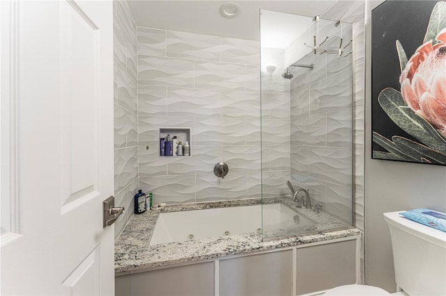 bathroom with toilet and tiled shower / bath