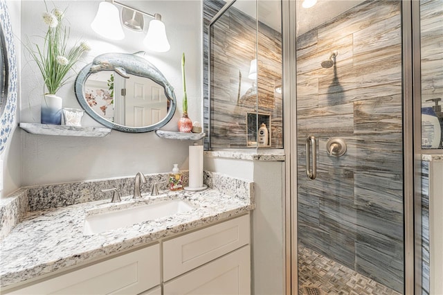 bathroom featuring vanity and a shower with shower door