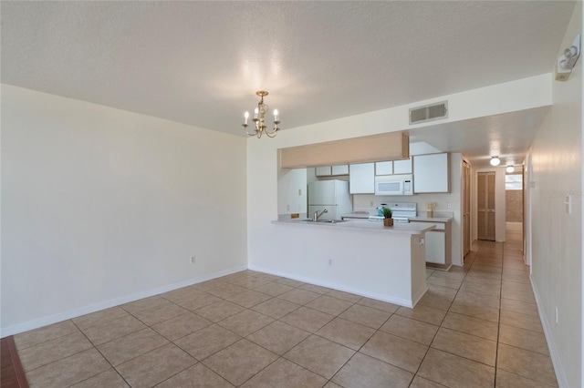 kitchen featuring white cabinetry, a notable chandelier, kitchen peninsula, white appliances, and light tile patterned floors