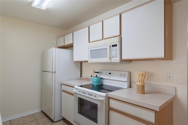 kitchen featuring a textured ceiling, white cabinets, light tile patterned flooring, and white appliances