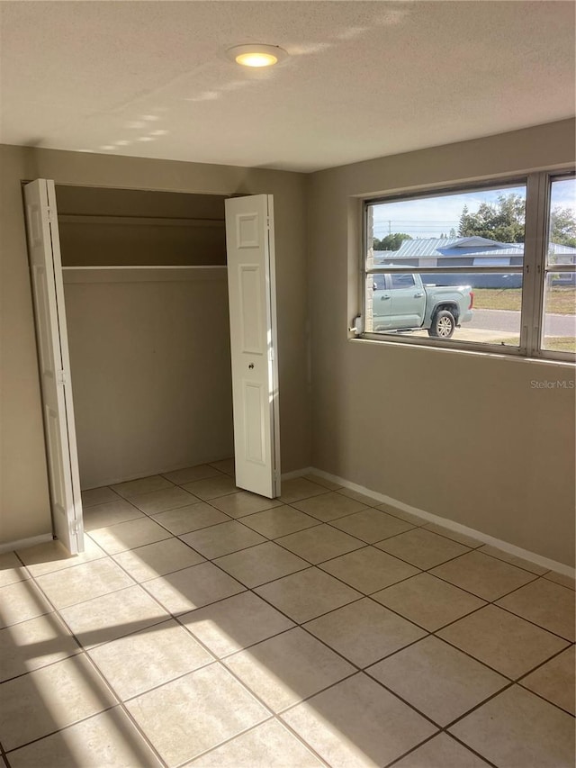 unfurnished bedroom featuring a closet and light tile patterned flooring