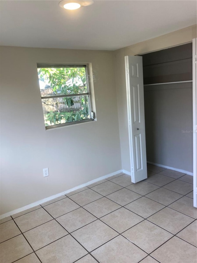 unfurnished bedroom with a closet and light tile patterned flooring