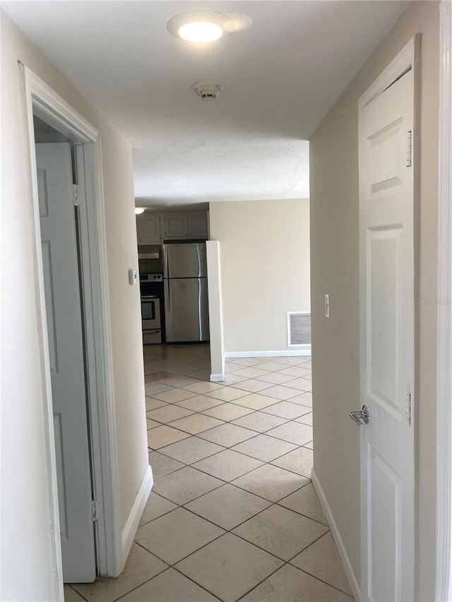 hall with light tile patterned floors